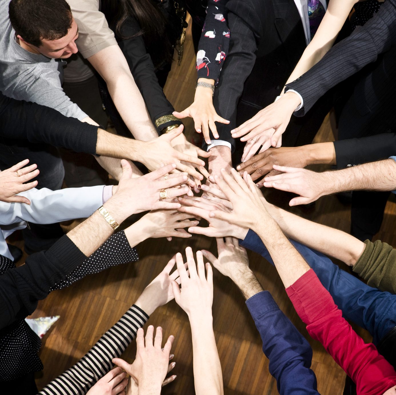 Hands of a diverse team brought together in the centre
