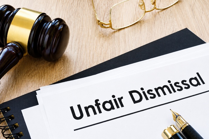 Employment tribunal papers headed Unfair Dismissal beside a gavel